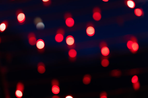 摘要离焦背景的明亮的红光。街道上不集中的闪闪发光的灯光。闪烁的红灯图片下载