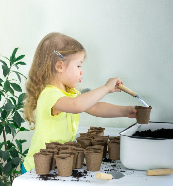 快乐的小女孩正在准备花盆和土壤，为新的春天播种种子图片下载