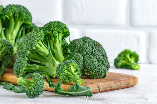 微距照片绿色新鲜蔬菜西兰花。花椰菜和西兰花。石头桌上放着新鲜的绿色花椰菜。西兰花蔬菜富含维生素。蔬菜的饮食和健康饮食。图片下载