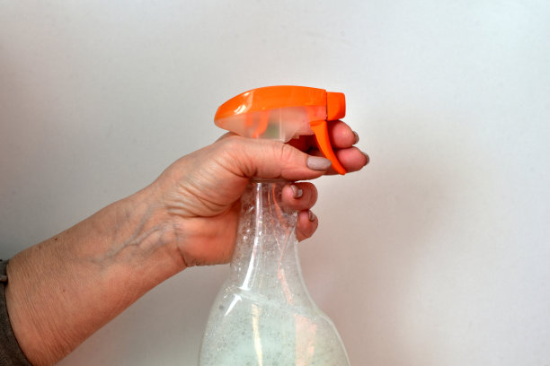 喷雾瓶是由一个女人的手拿着的。图片下载