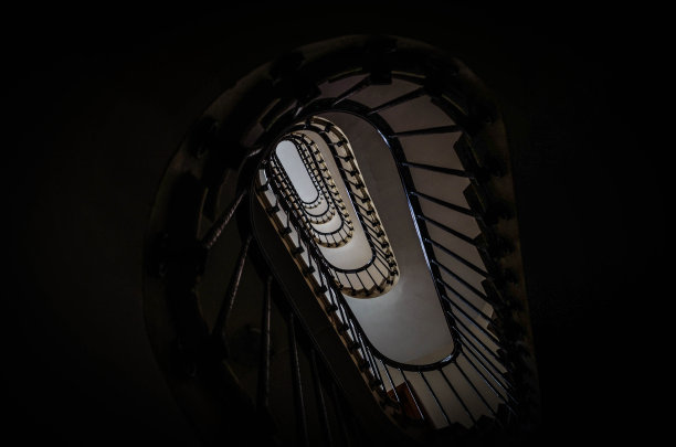 巴黎市中心街道上一座老建筑的椭圆木楼梯间图片下载