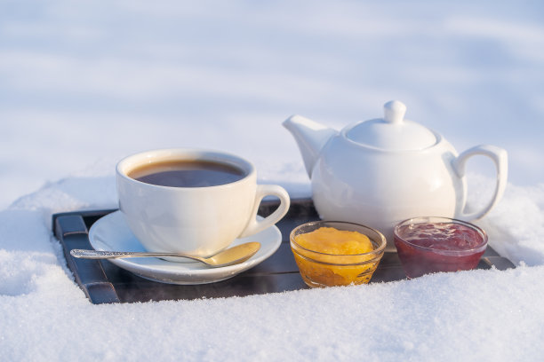 白色的茶杯和茶壶放在白雪和白色的背景上图片下载