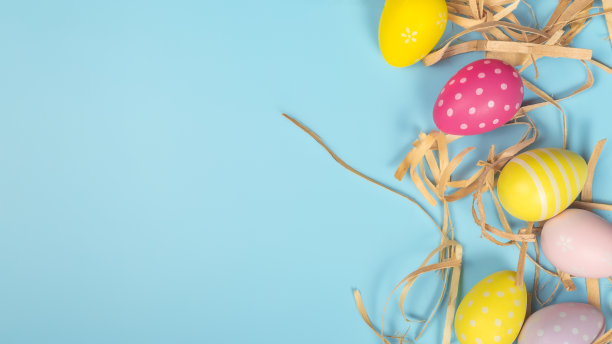 复活节快乐的概念。复活节彩蛋放在鸟巢上，贺卡和蓝色背景上。平铺，俯视图，复制空间。图片下载