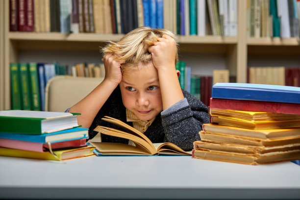 男孩在图书馆学习时看起来很无聊图片下载