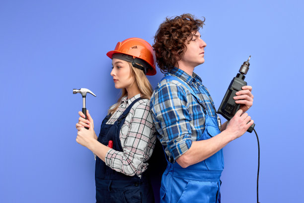 侧面视图自信的建设者团队，建设者背靠背地站在彼此拿着工具图片下载