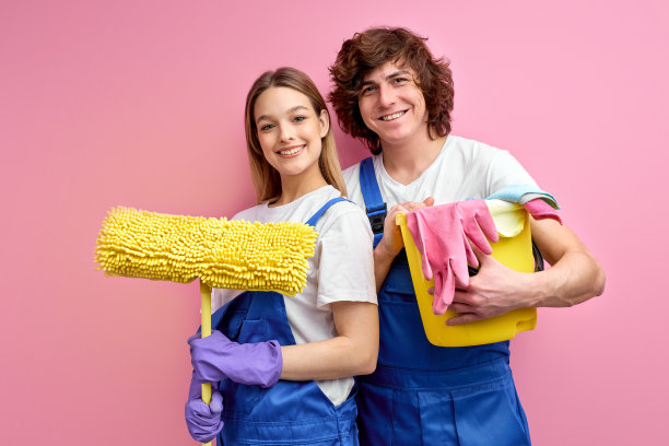 乐观的夫妇用抹布和其他工具清洁，在镜头前摆姿势图片下载