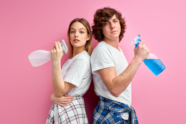 管家的概念。自信的白人夫妻带着清洁用品被隔离在粉红色图片下载