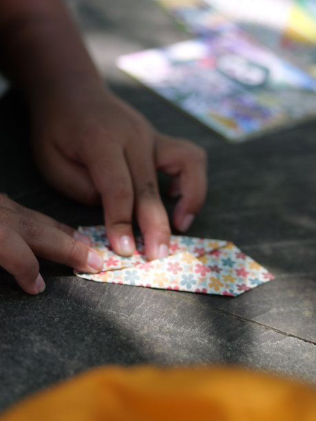 学习折纸。孩子在餐桌上折纸。有选择性的重点。图片下载