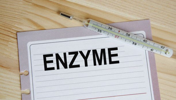 酶字在一张蓝色的纸上，背景是五颜六色的药片。医学概念。图片下载