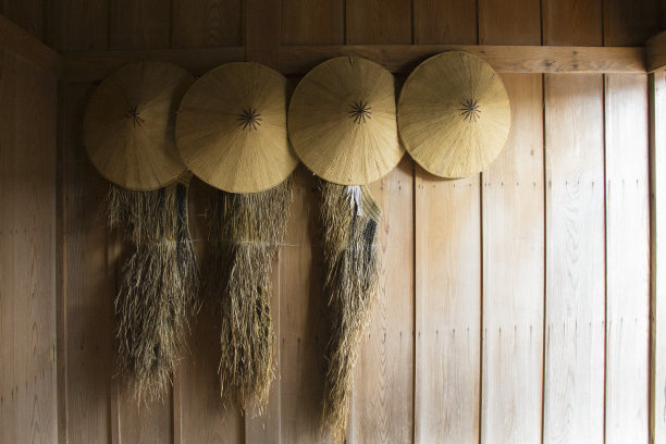 古老的木墙装饰着传统的日本帽子和雨衣图片下载