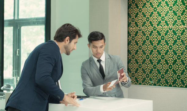 航空公司地勤人员帮助乘客检查机票和护照。图片下载