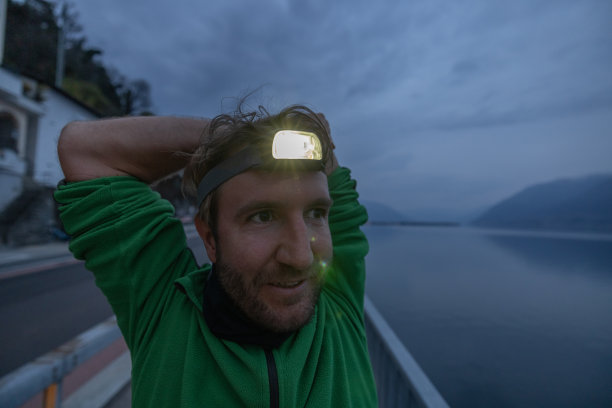 准备晚跑的男子伸伸身体，头灯图片下载