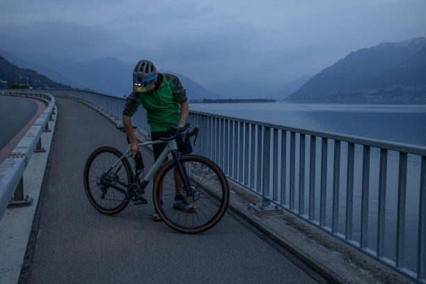 晚上骑自行车训练的男子在自行车道上休息图片下载