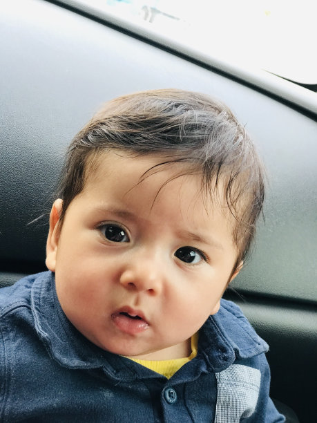 男婴的肖像。笑脸和活泼的面部表情。可爱的婴儿。垂直的照片。图片下载