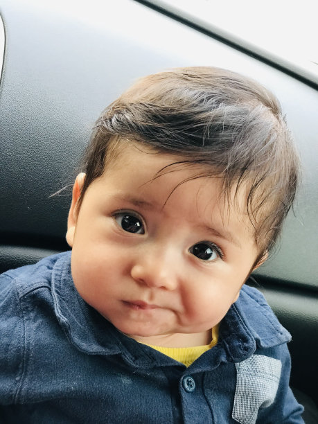 男婴的肖像。笑脸和活泼的面部表情。可爱的婴儿。垂直的照片。图片下载