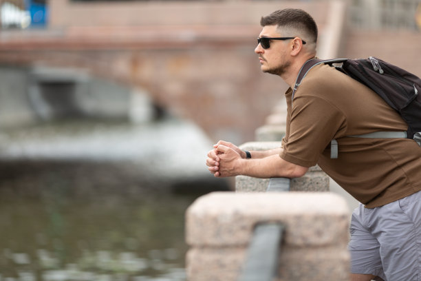 男人靠在堤岸栏杆上，若有所思地看着图片下载