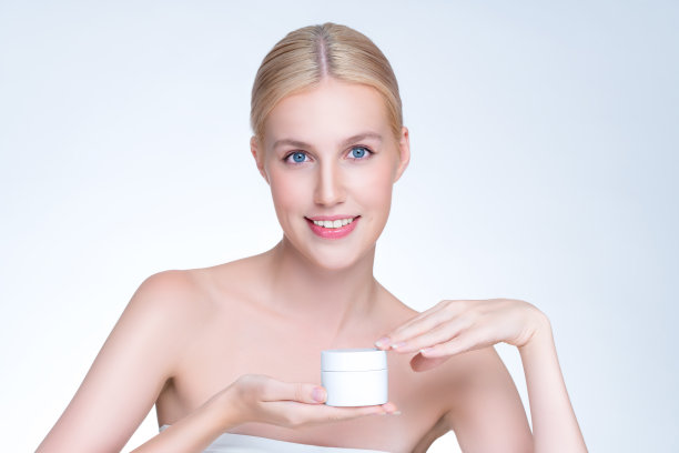 风度翩翩的完美皮肤女人拿着模型保湿产品。图片下载