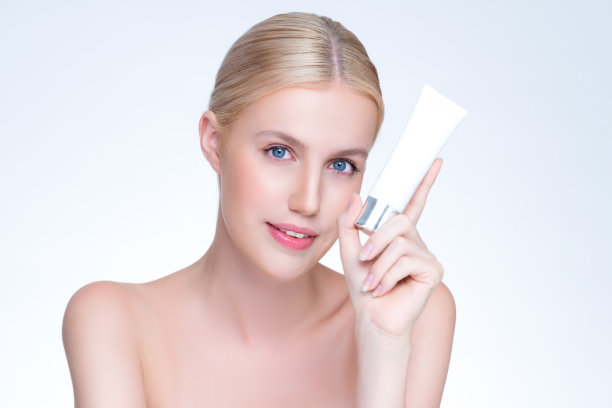 风度翩翩的完美皮肤女人拿着模型保湿产品。图片下载