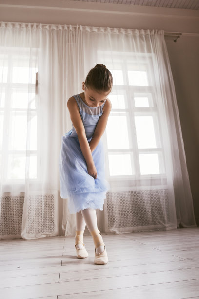 穿着蓝色紧身衣和裙子的芭蕾舞女演员正在表演芭蕾舞舞步图片下载