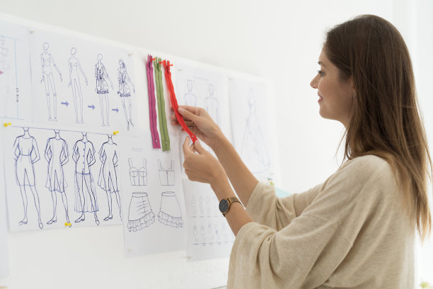 女裁缝在裁缝店为面料纺织品选择金属拉链或扣件图片下载