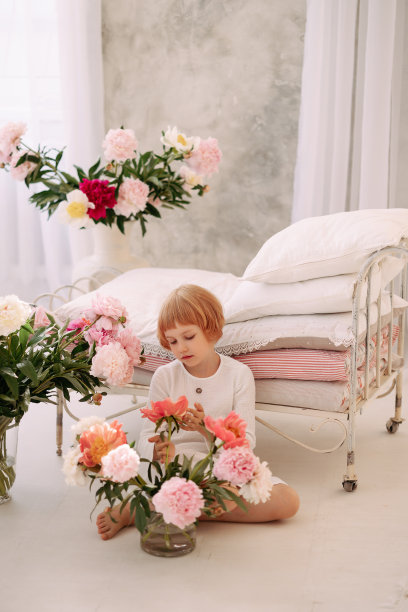 一个6-7岁的女孩穿着白色的裙子，手里拿着一朵花图片下载