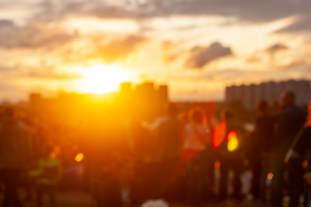 人们在城里看日落。人们在大都市公园的湖边欣赏日落。城市公园里的人们和日落图片下载