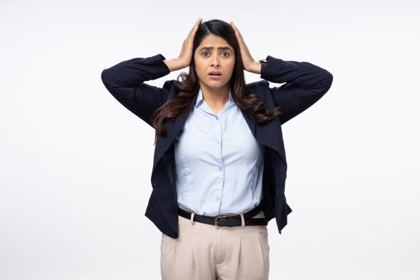 好奇沮丧的年轻女商人的肖像，双手放在头上，看着白色背景上的相机。库存图片图片下载