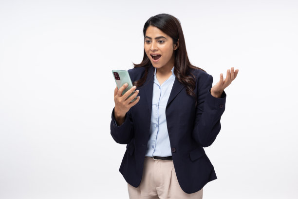 年轻女企业家的肖像，用手机在线工作或聊天，白色背景，库存照片图片下载