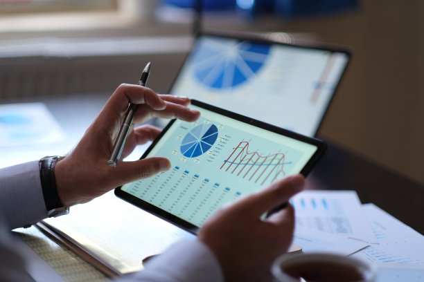 商人正在从数字平板电脑屏幕上分析业务表现和数据图片下载