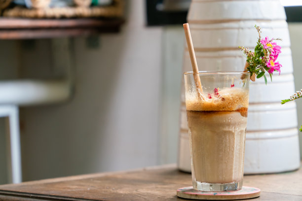 早上的咖啡杯装饰着鲜花，模糊的前景和背景的焦点。库存图片图片下载