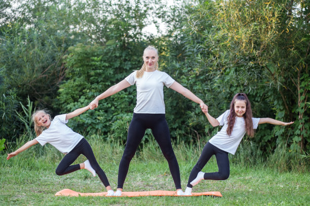 儿童体操。与孩子们一起在户外运动垫上进行体育锻炼。图片下载