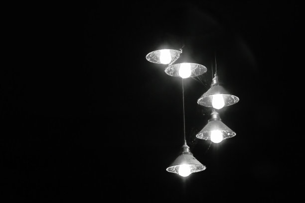 夜晚，天花板上挂着一盏黑白色调的电灯图片下载