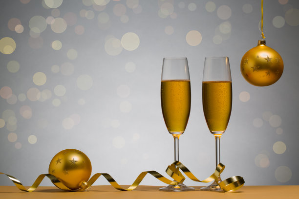 棕色桌子上有两个香槟杯和圣诞球的照片图片下载