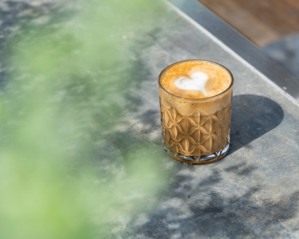 铁桌上有心形拉花图案的拿铁咖啡杯。有选择性的重点。库存图片图片下载