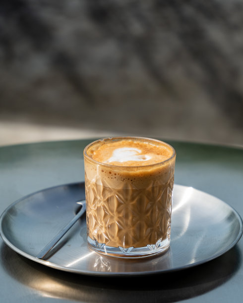 铁桌上有心形拉花图案的拿铁咖啡杯。有选择性的重点。库存图片图片下载