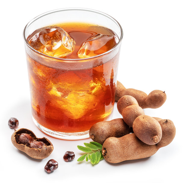 一杯清凉的罗望子饮料，白色背景上有一些罗望子。图片下载