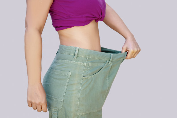 女人穿太大的裤子。有效的减肥理念。图片下载