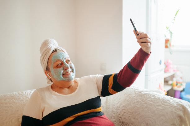 真正的女人放松并为老年人的护肤自拍充电图片下载