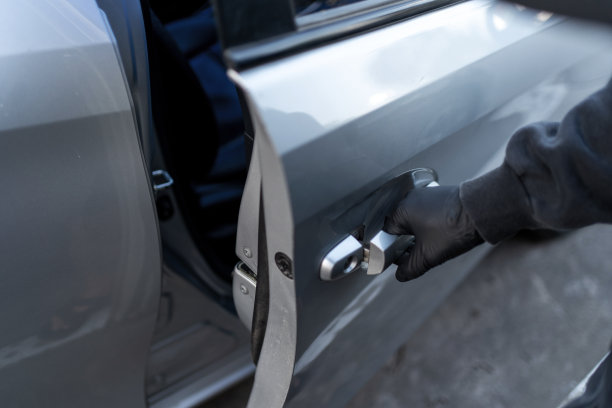 小偷在白天的城市街道上偷汽车。图片下载