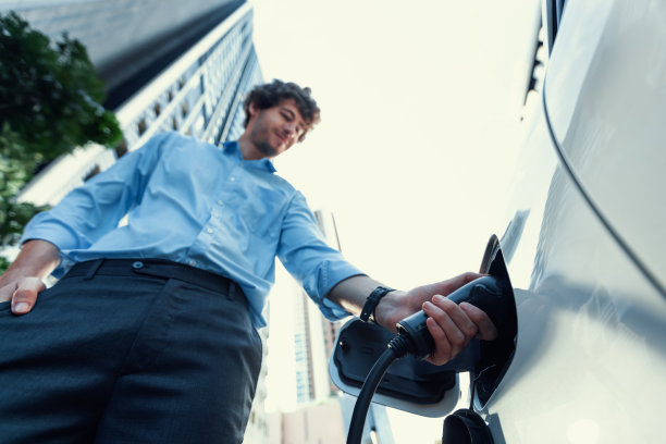 鱼眼观西装革履的进步商人与他的电动车。图片下载