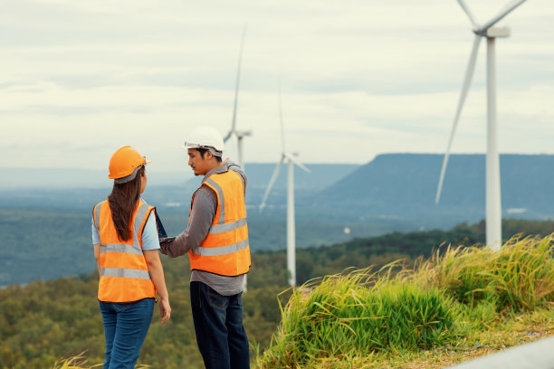 工程师在山顶风力发电场工作的进步概念。图片下载