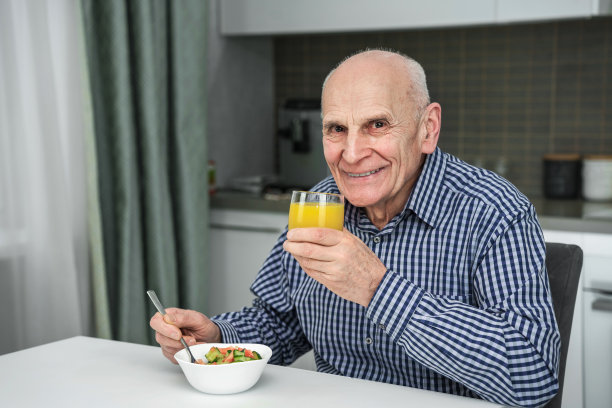 微笑快乐的老人，午餐有沙拉和果汁图片下载