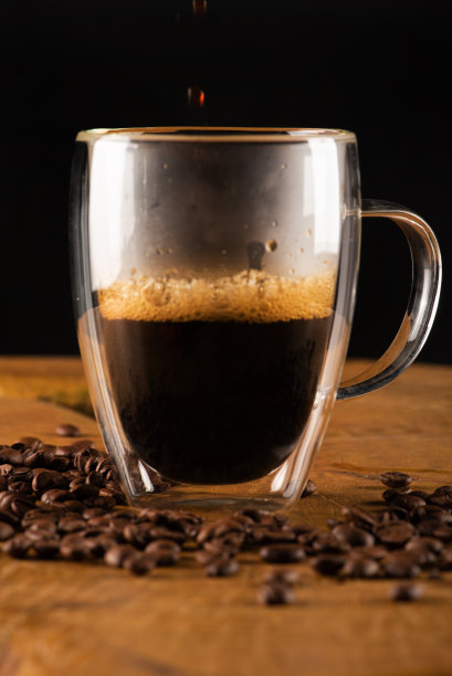 玻璃杯，玻璃杯上的咖啡与质朴的木头，选择性重点。图片下载