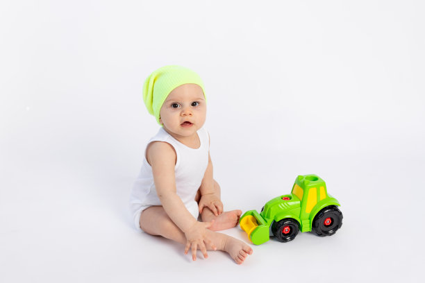 可爱的小男孩穿着白色的紧身衣，在白色孤立的背景上玩打字机，婴儿发育早期，8个月大的婴儿在玩具中间，有文字的空间图片下载