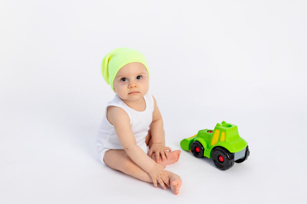 可爱的小男孩穿着白色的紧身衣，在白色孤立的背景上玩打字机，婴儿发育早期，8个月大的婴儿在玩具中间，有文字的空间图片下载