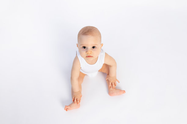可爱的小男孩在白色隔离背景上穿着白色紧身衣看着镜头，婴儿8个月大，空白文字图片下载