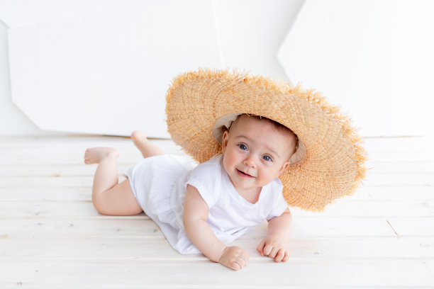 有趣可爱的孩子女孩3-4岁手持草帽，穿着白色上衣和牛仔短裤，在自然背景的公园里摆姿势。幸福。夏天的季节。图片下载