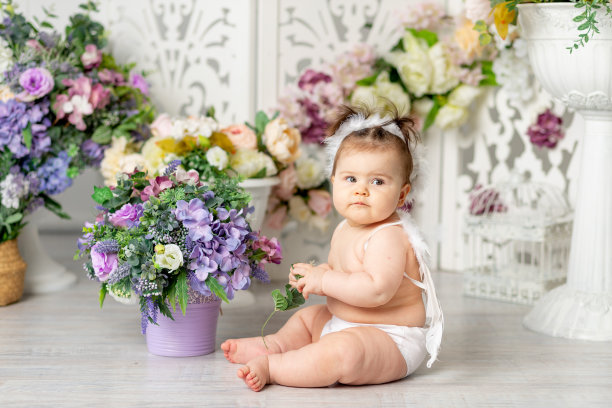 带着天使翅膀的宝贝在花丛中，情人节的概念，图片下载