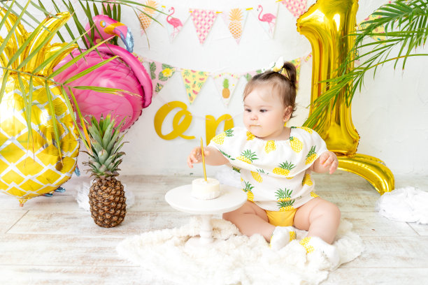 一个一岁女婴的生日，一个蛋糕和一支蜡烛，假期的概念和生日照片区的设计图片下载