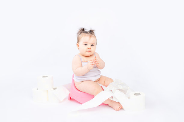 婴儿放在绿色便盆上，白色绝缘背景上有卫生纸，有文字空间图片下载